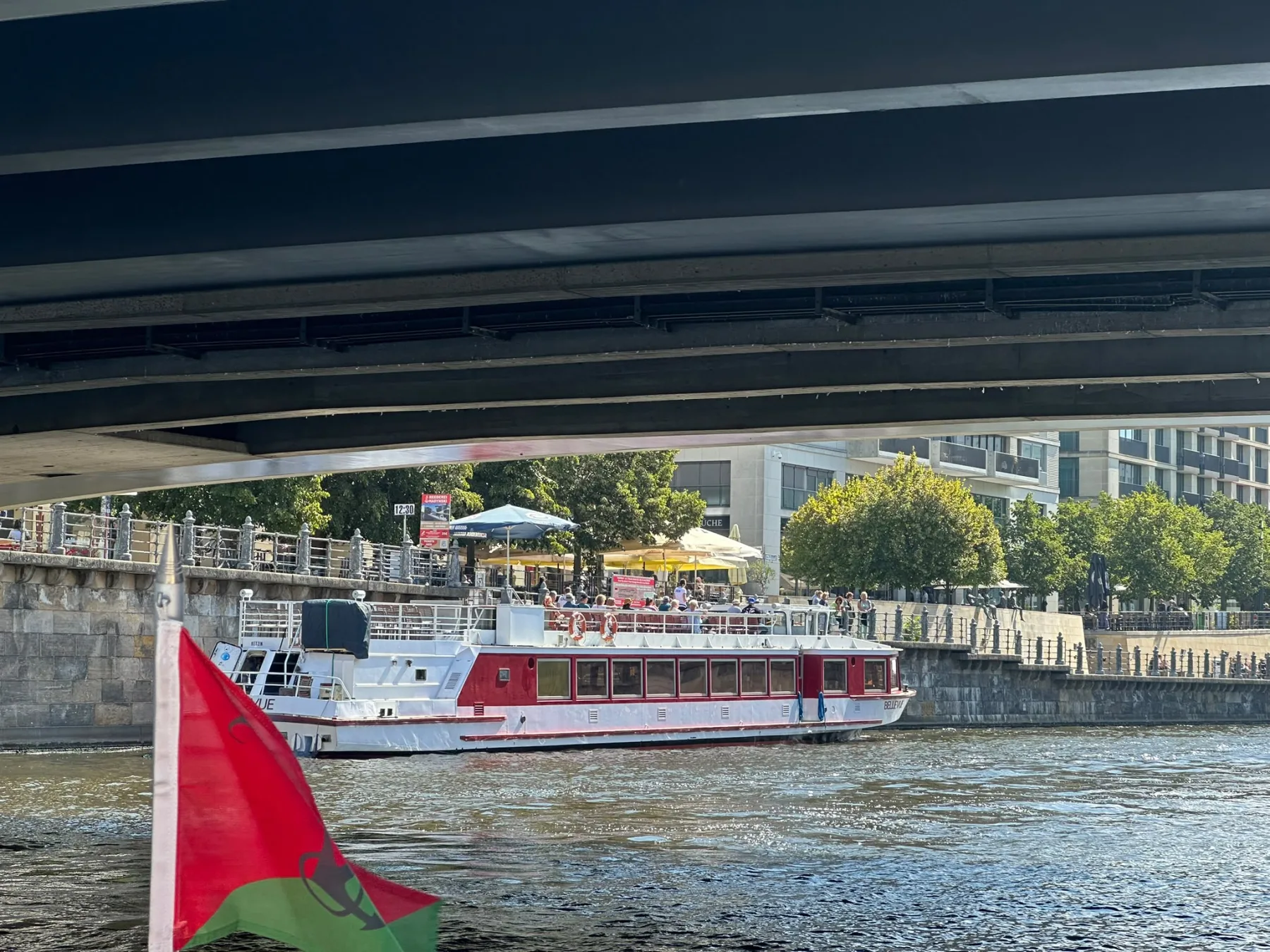 Fahrgastschiff vor einem modernen Gebäude am Spreeufer