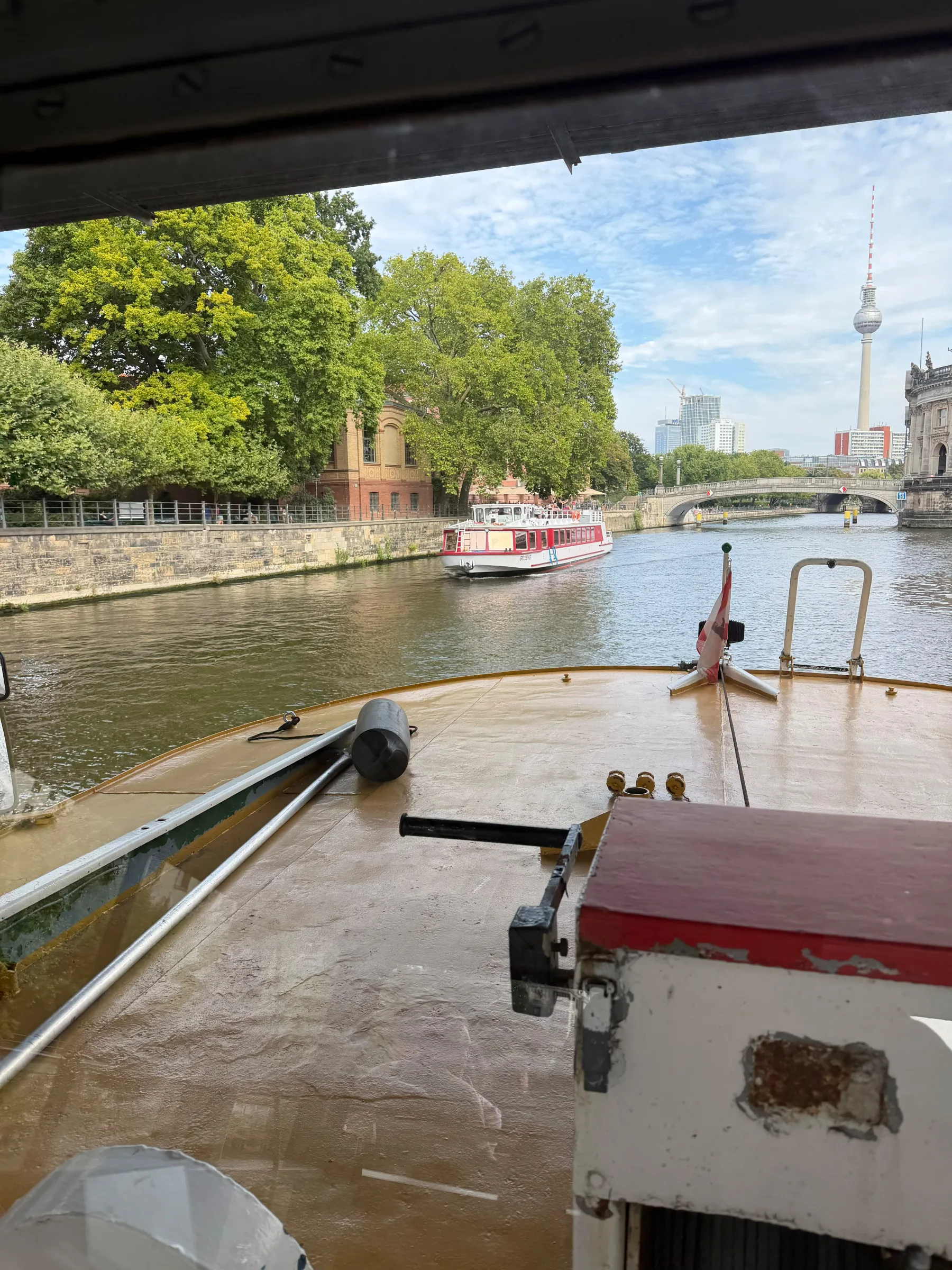 Offenes Bootsdeck und grüne Ufer der Spree