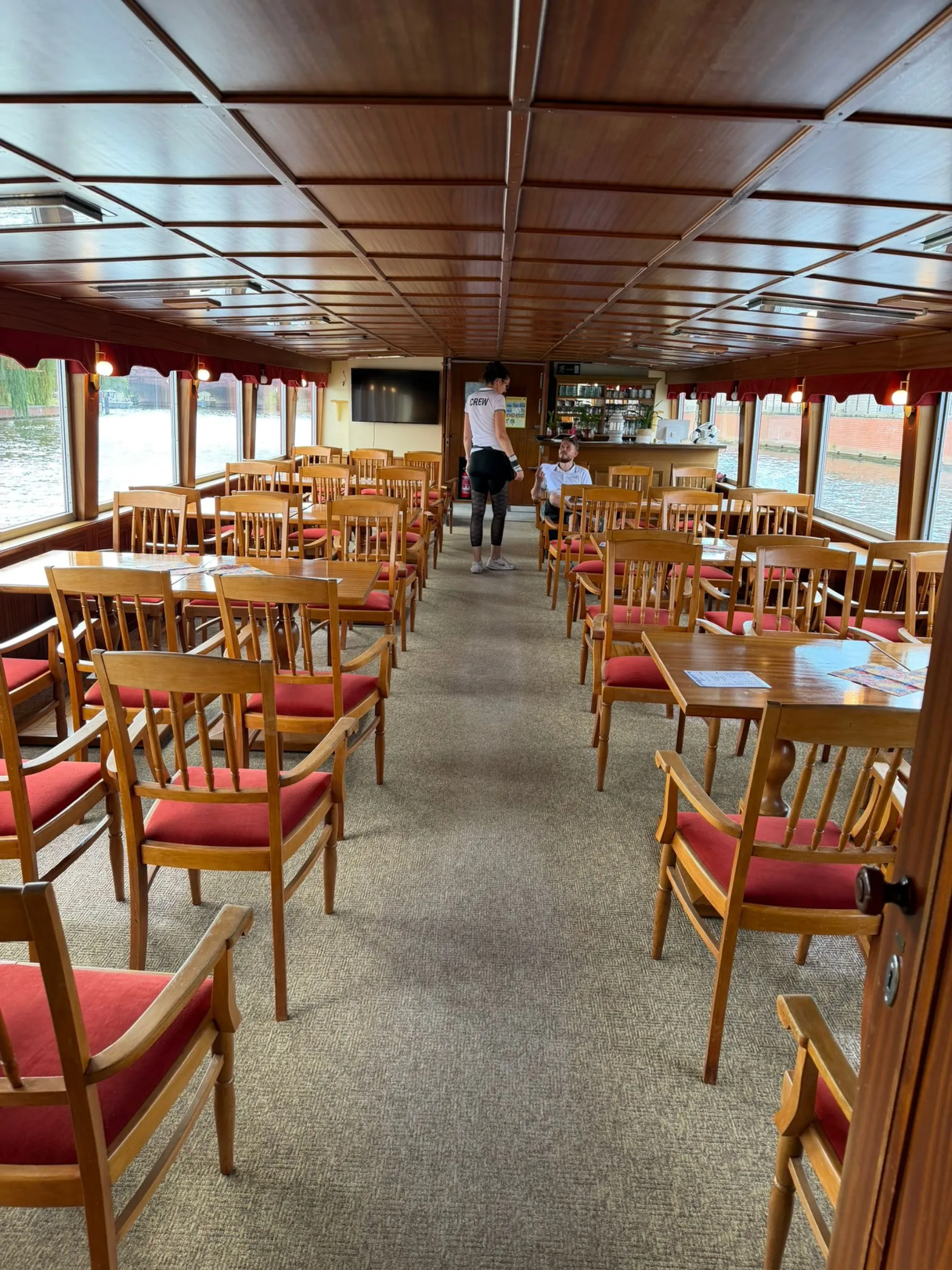 Holzvertäfelter Salon mit Tischen und Stühlen