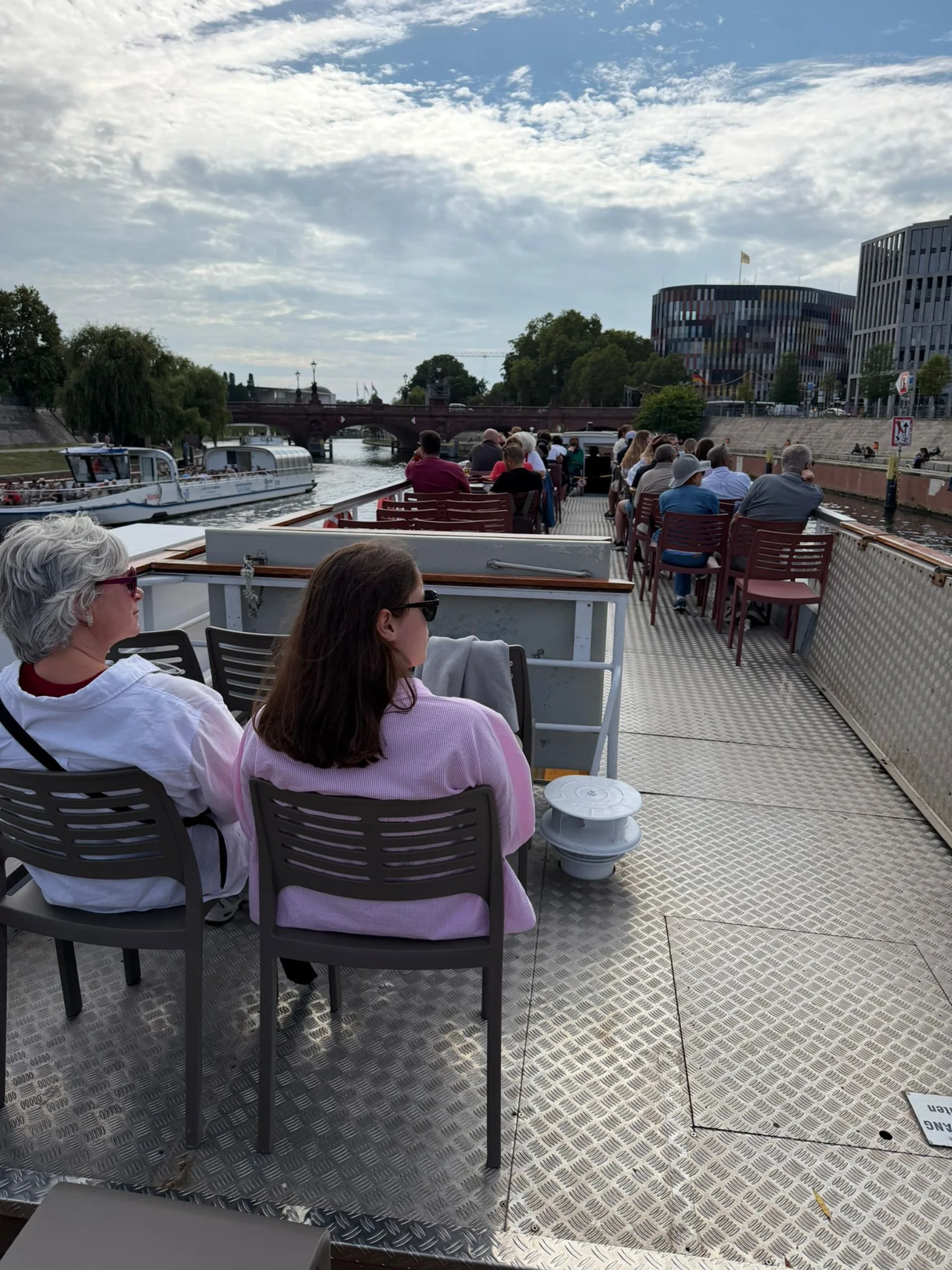 Gäste sitzen auf dem Außendeck während der Fahrt