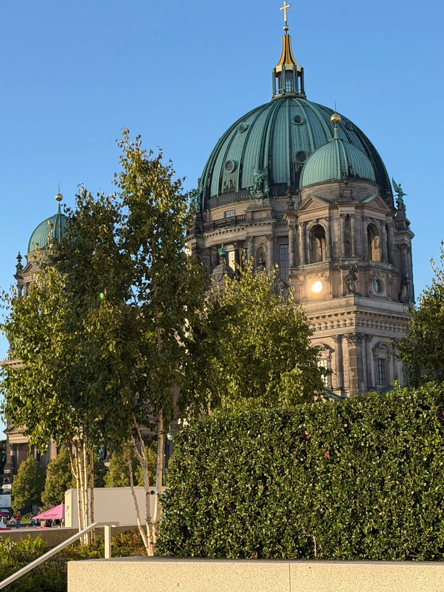 Berliner Dom hinter grünen Bäumen am Spreeufer