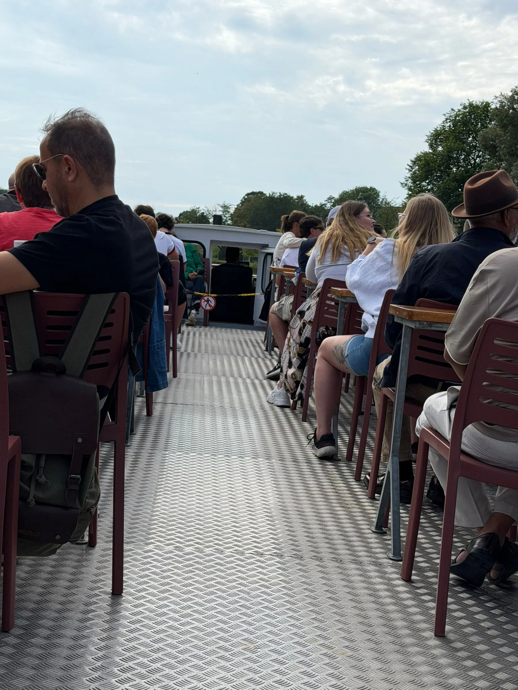 Passagiere sitzen auf dem Außendeck der Spreefahrt