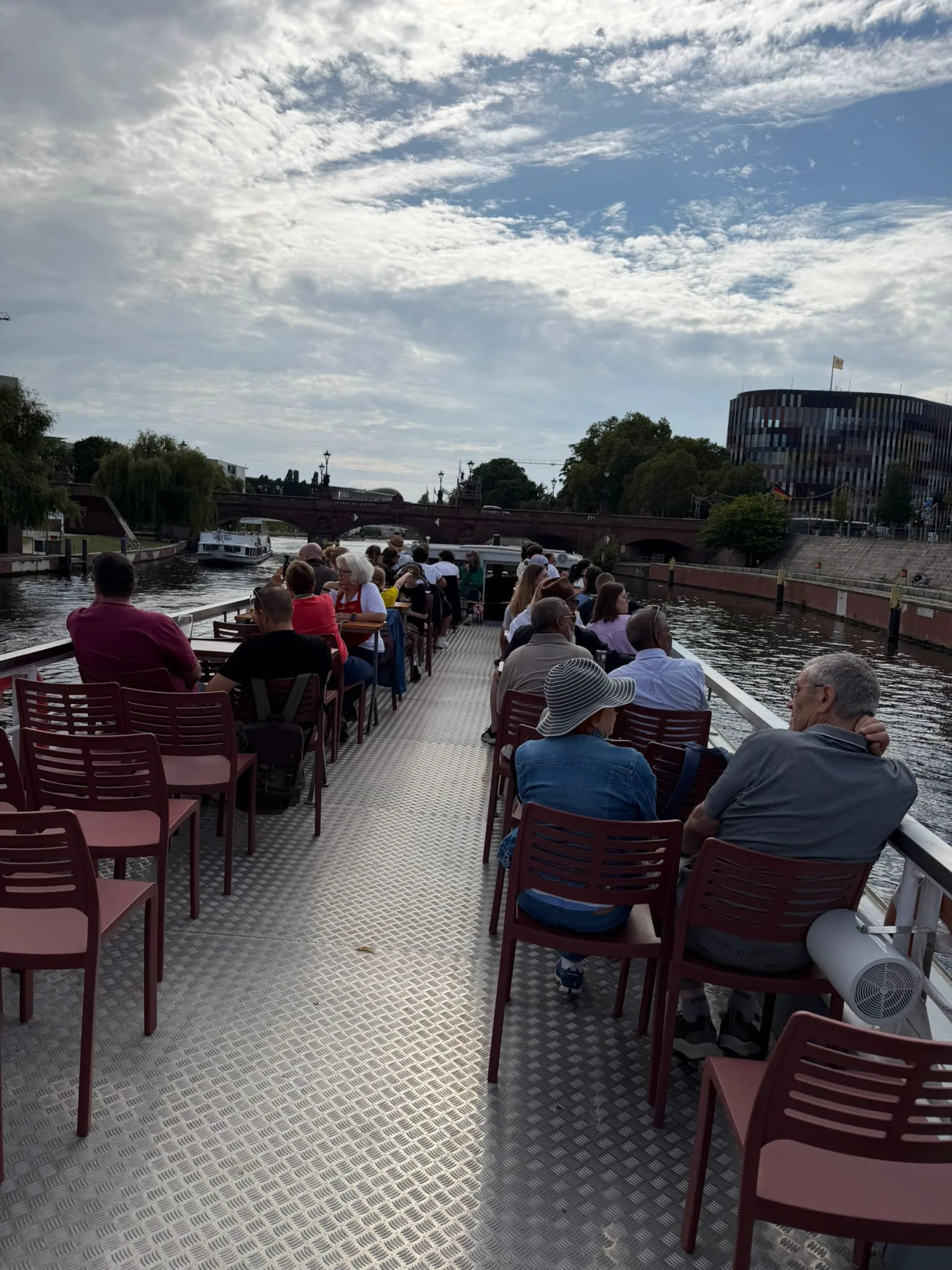 Gäste an Bord schauen auf die vorbeiziehende Stadt